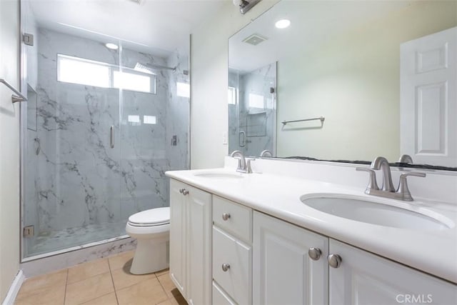 bathroom with a sink, a marble finish shower, toilet, and double vanity