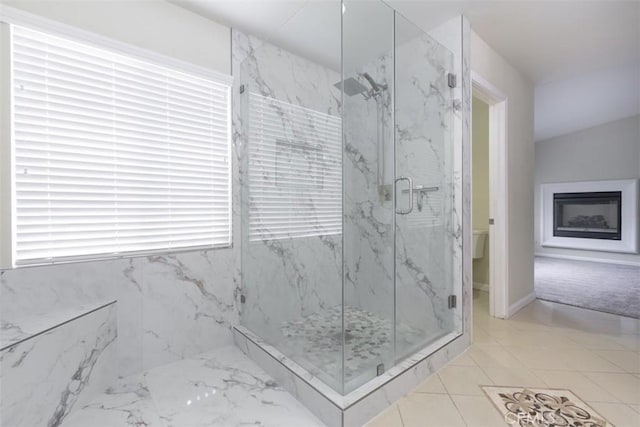 bathroom with a marble finish shower and a fireplace