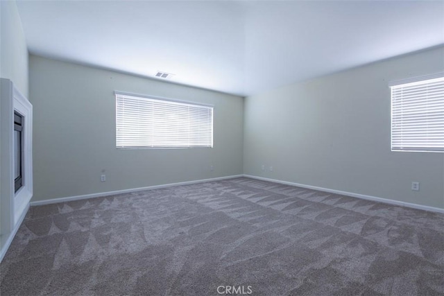 unfurnished room with visible vents, baseboards, and carpet flooring