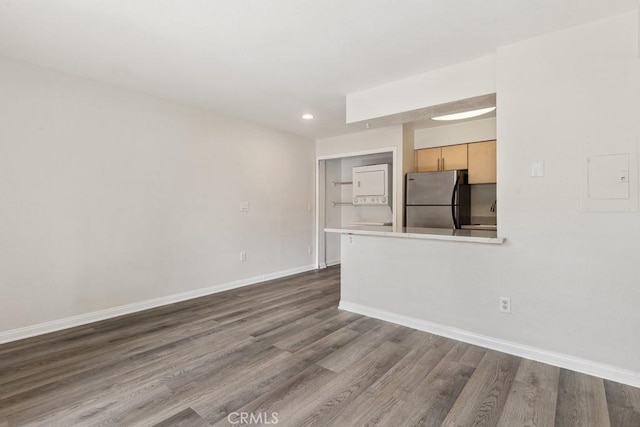 unfurnished living room featuring recessed lighting, baseboards, and dark wood-type flooring