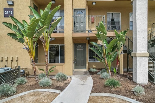 doorway to property featuring a balcony and stucco siding