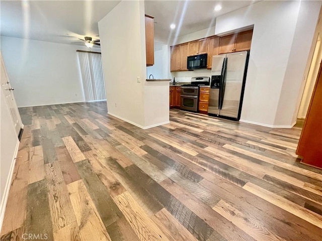 kitchen with dark countertops, ceiling fan, open floor plan, light wood-type flooring, and stainless steel appliances