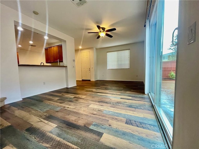 unfurnished living room featuring visible vents, a ceiling fan, and wood finished floors