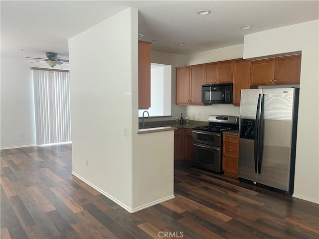 kitchen featuring dark wood finished floors, brown cabinets, appliances with stainless steel finishes, and ceiling fan