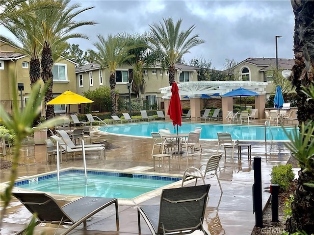 pool with a hot tub and a patio area