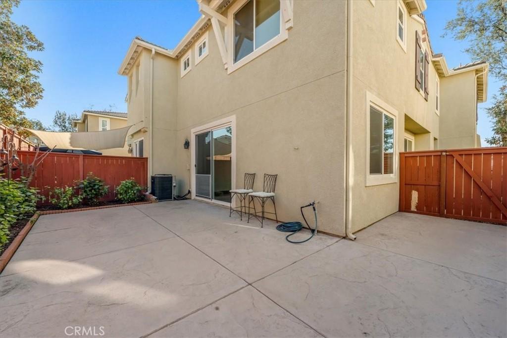 back of property featuring stucco siding, central AC, a patio, and fence