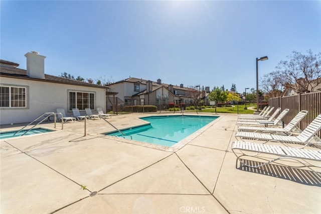 community pool with a residential view, a patio, and fence