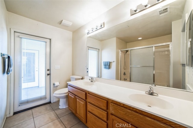 bathroom with a sink, visible vents, a shower stall, and tile patterned floors