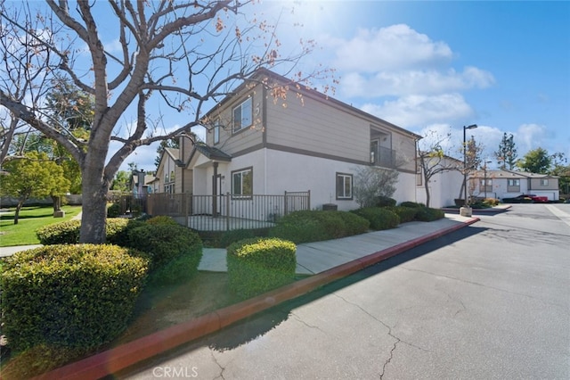 view of side of property featuring a residential view and stucco siding