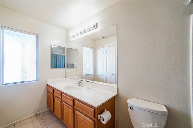 bathroom featuring tile patterned floors, baseboards, toilet, and vanity