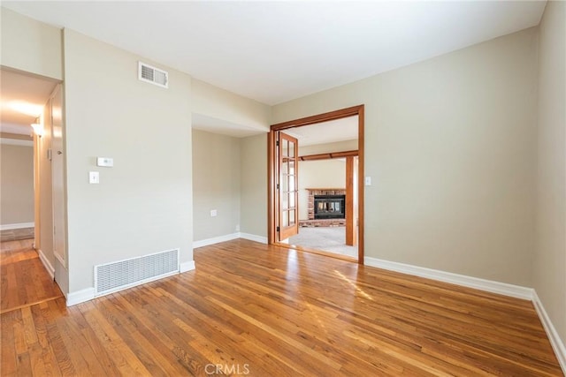 spare room with light wood-style flooring, baseboards, and visible vents