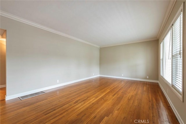 spare room with visible vents, baseboards, and wood finished floors