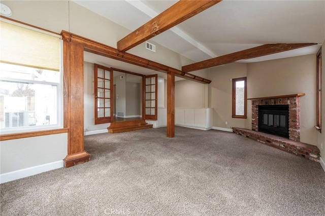 unfurnished living room featuring a wealth of natural light, visible vents, vaulted ceiling with beams, and carpet flooring