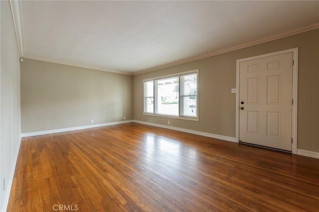 interior space with baseboards, wood finished floors, and ornamental molding