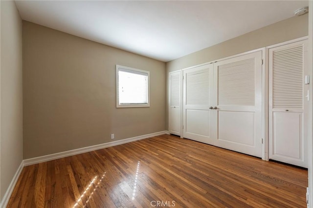 unfurnished bedroom featuring baseboards and wood finished floors