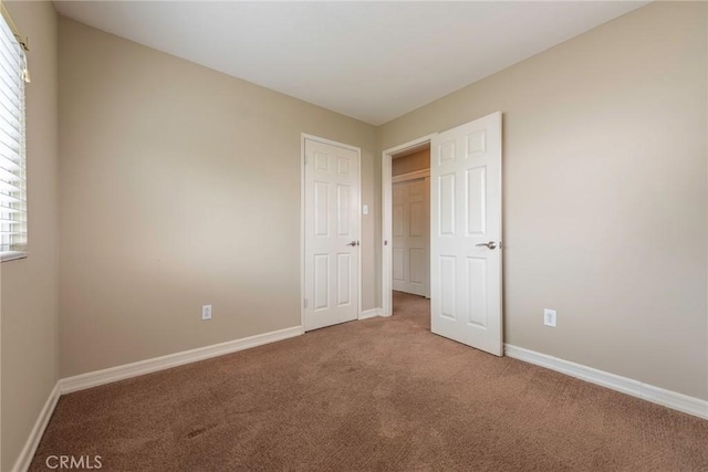 unfurnished bedroom with baseboards and carpet flooring