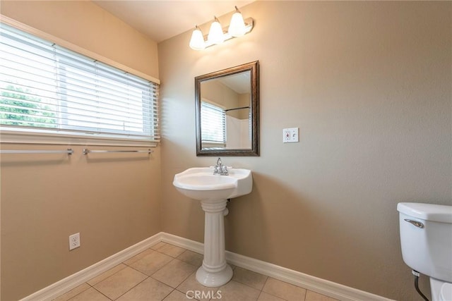 bathroom featuring tile patterned floors, baseboards, and toilet