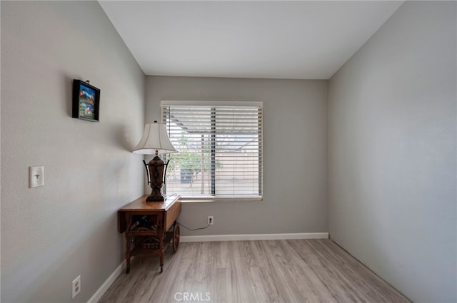 empty room with baseboards and light wood finished floors