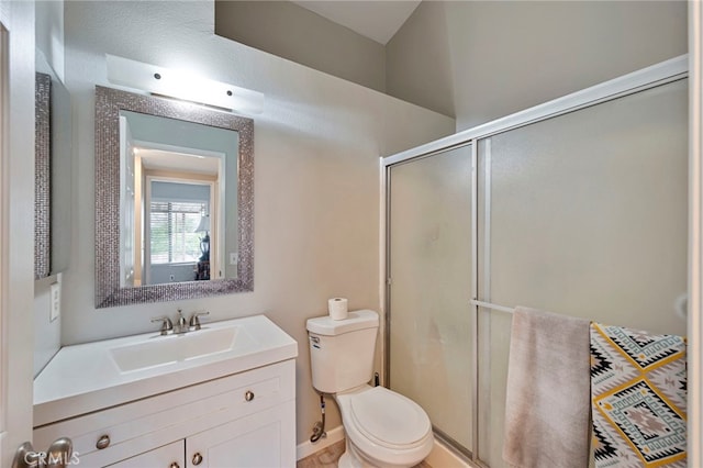 bathroom with a stall shower, toilet, and vanity