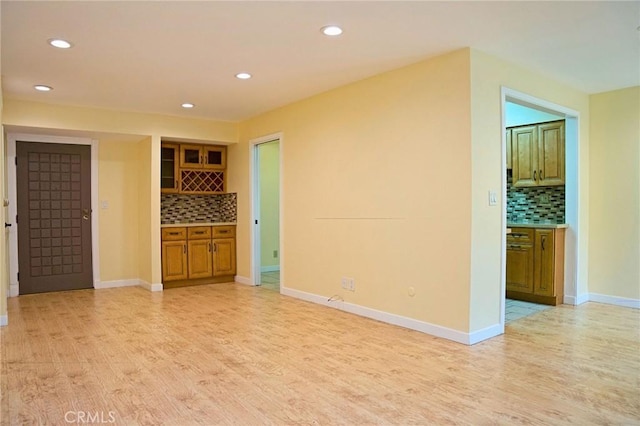 spare room featuring recessed lighting, baseboards, and light wood-type flooring