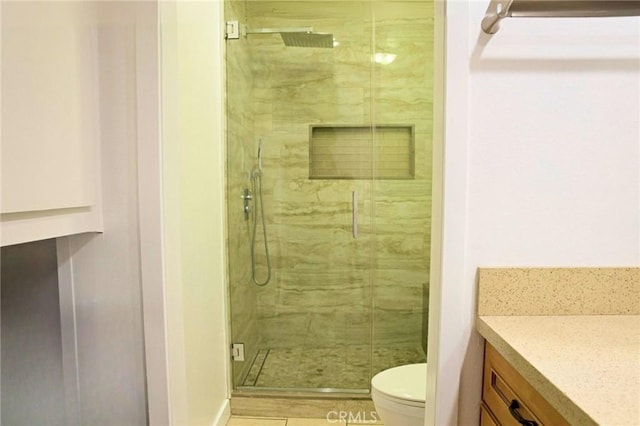 bathroom featuring a marble finish shower, toilet, and vanity