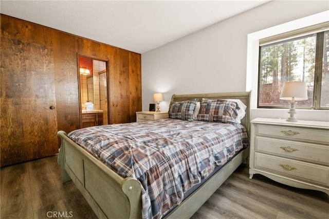 bedroom with wood walls and wood finished floors