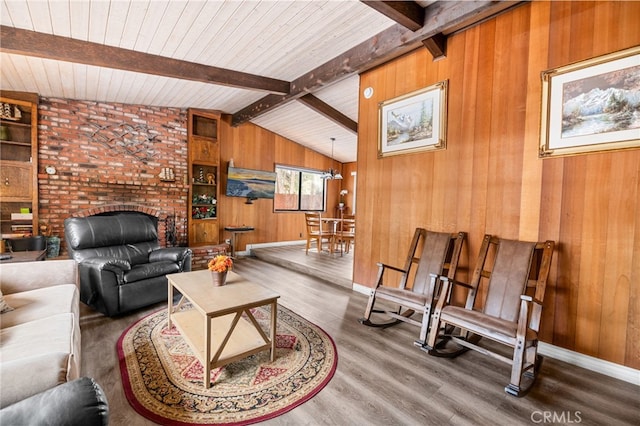 living room with wooden walls, wood finished floors, baseboards, vaulted ceiling with beams, and wood ceiling