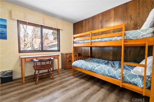 bedroom with baseboards and wood finished floors