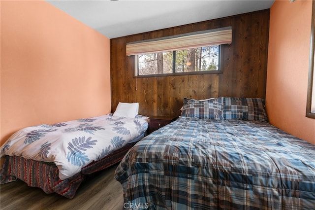 bedroom with wooden walls and wood finished floors