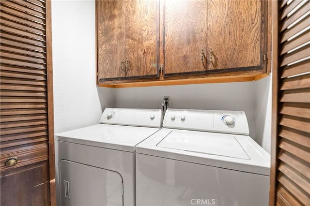 clothes washing area with cabinet space and washing machine and clothes dryer