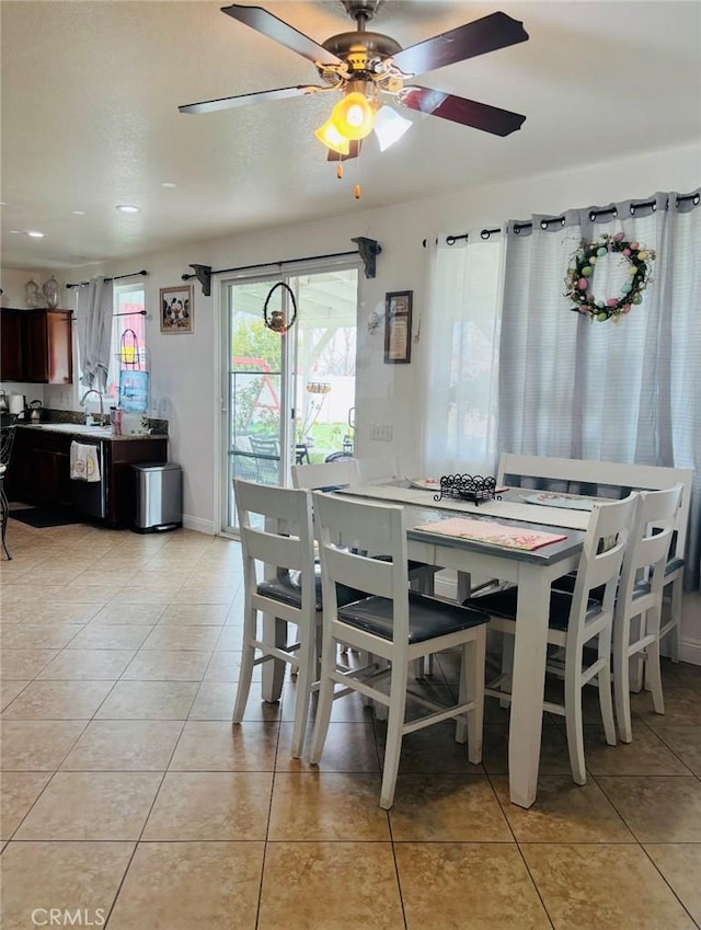 dining space with light tile patterned floors, baseboards, and a ceiling fan