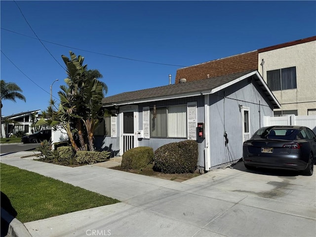 view of front of property with fence and a shingled roof