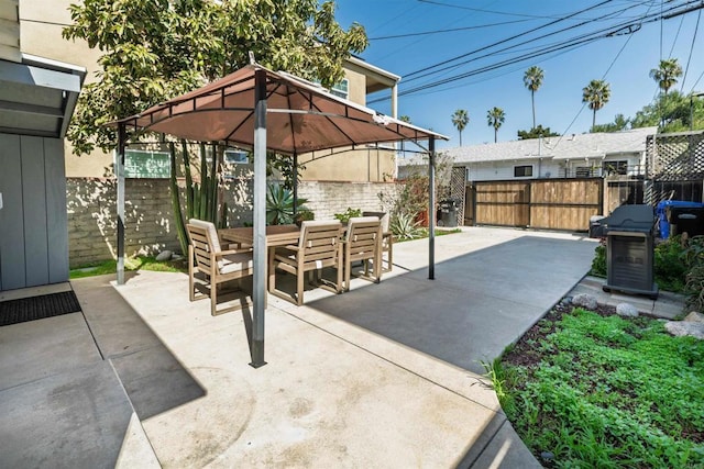 view of patio featuring a gazebo, outdoor dining area, and a fenced backyard