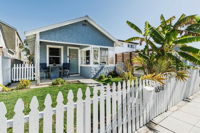 view of front of home featuring a fenced front yard and covered porch