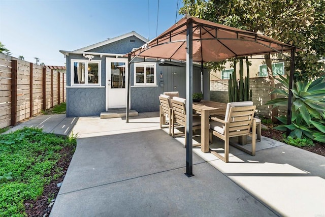 view of patio / terrace with a gazebo, outdoor dining space, and fence