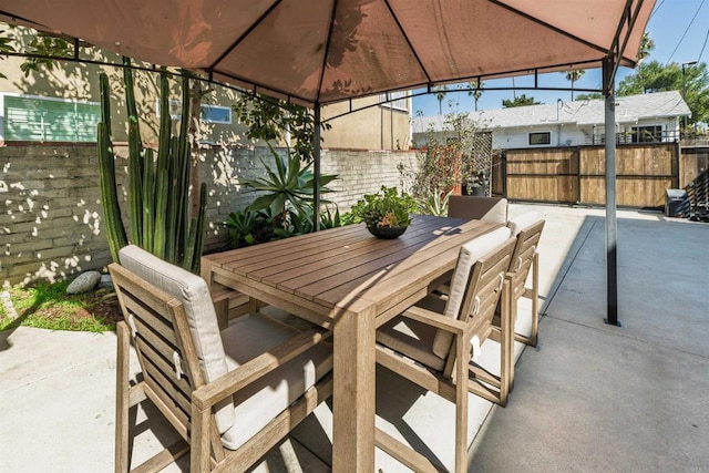 view of patio / terrace with outdoor dining space, a gazebo, and fence