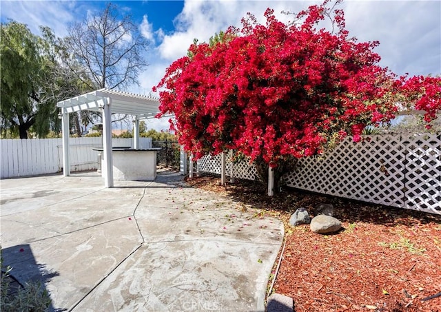 view of patio with a pergola and fence