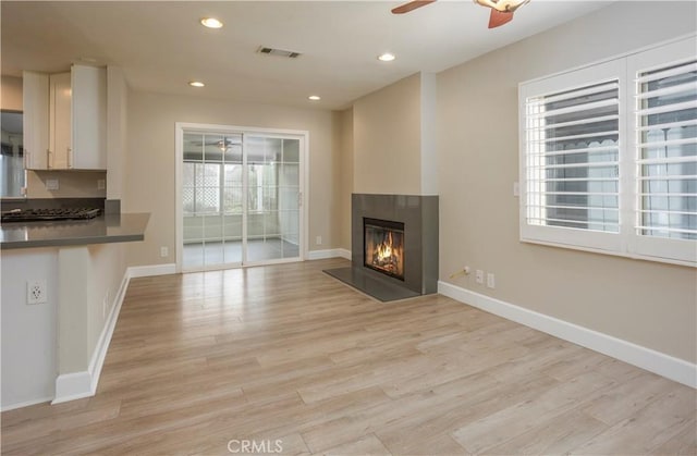 unfurnished living room with a ceiling fan, baseboards, visible vents, recessed lighting, and light wood-type flooring