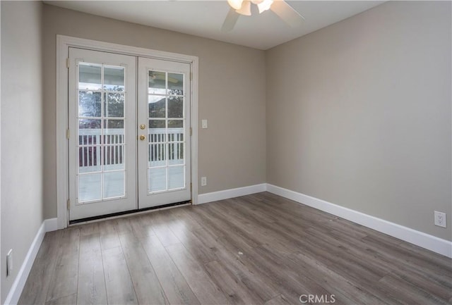 spare room with wood finished floors, french doors, baseboards, and ceiling fan