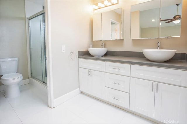 bathroom featuring double vanity, a stall shower, toilet, and a sink