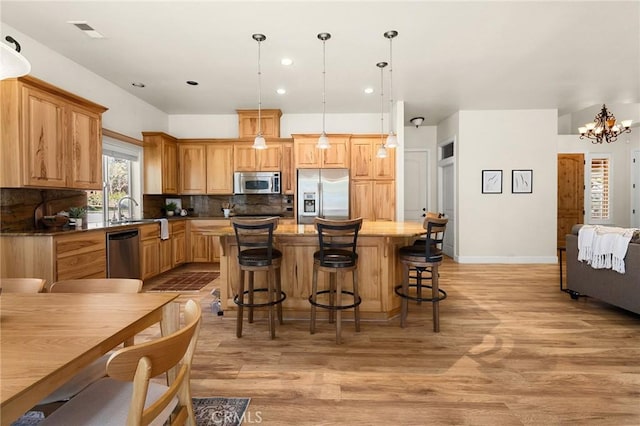 13725 Nimshew Rd, Magalia, CA 95954 - kitchen with visible vents, stainless steel appliances, decorative backsplash, light wood-type flooring, and a center island