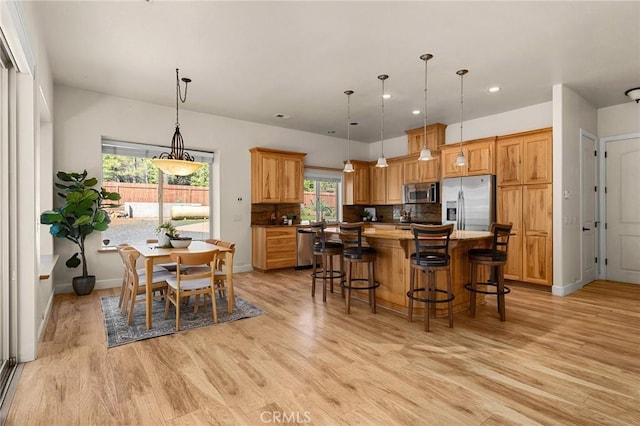13725 Nimshew Rd, Magalia, CA 95954 - kitchen featuring tasteful backsplash, a kitchen island, light wood-style flooring, and stainless steel appliances