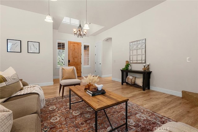13725 Nimshew Rd, Magalia, CA 95954 - living area with baseboards, lofted ceiling, an inviting chandelier, light wood-style floors, and arched walkways
