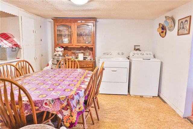 dining room featuring a textured ceiling, baseboards, light floors, and washer and clothes dryer