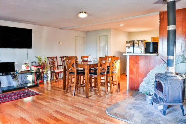 dining room with a wood stove and wood finished floors