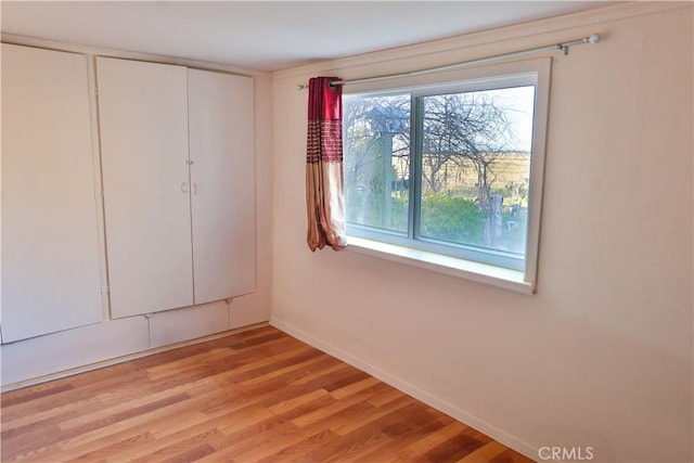 unfurnished room featuring light wood-style flooring and baseboards