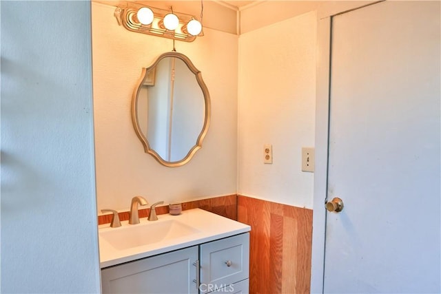 bathroom featuring vanity, a wainscoted wall, and wood walls