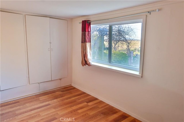 spare room with light wood-type flooring and baseboards