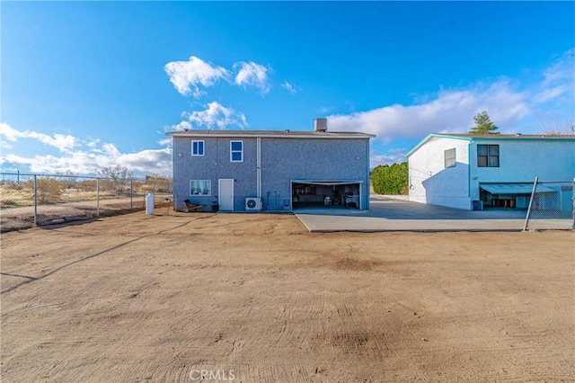 rear view of property featuring fence and a garage