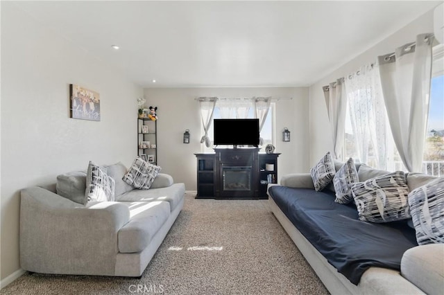 carpeted living area with baseboards